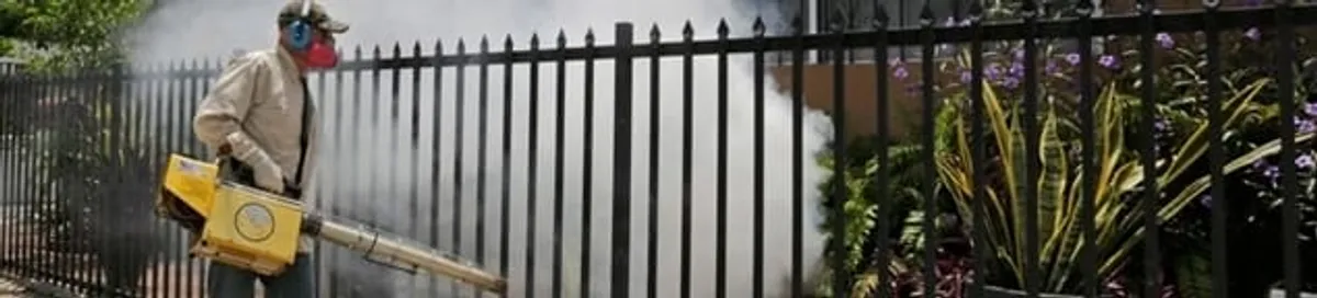 Mosquito control technician fogging a yard perimeter for mosquito reduction in Bakersfield, CA